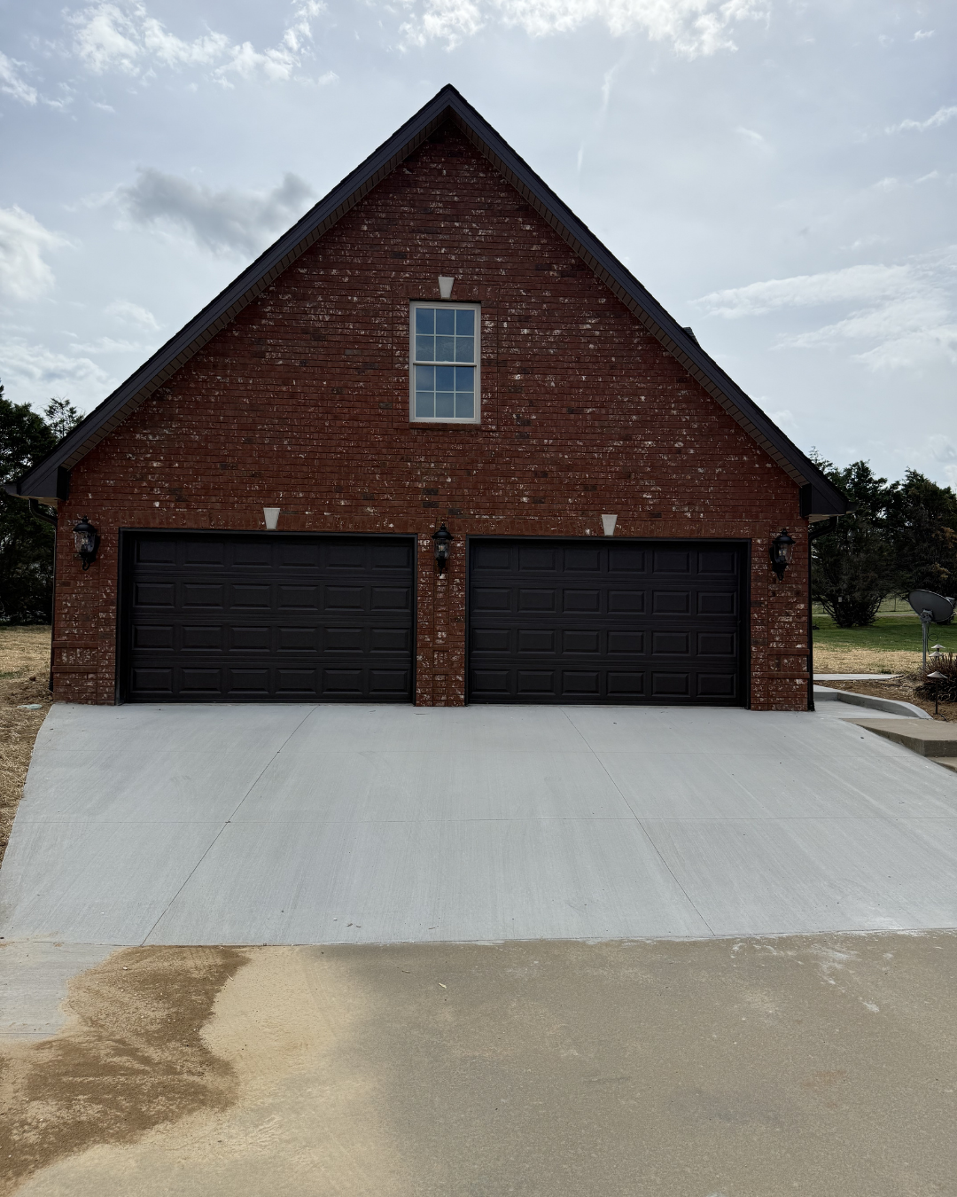 Custom 3-car brick garage with black doors, Clarksville TN — Yarbrough Homes